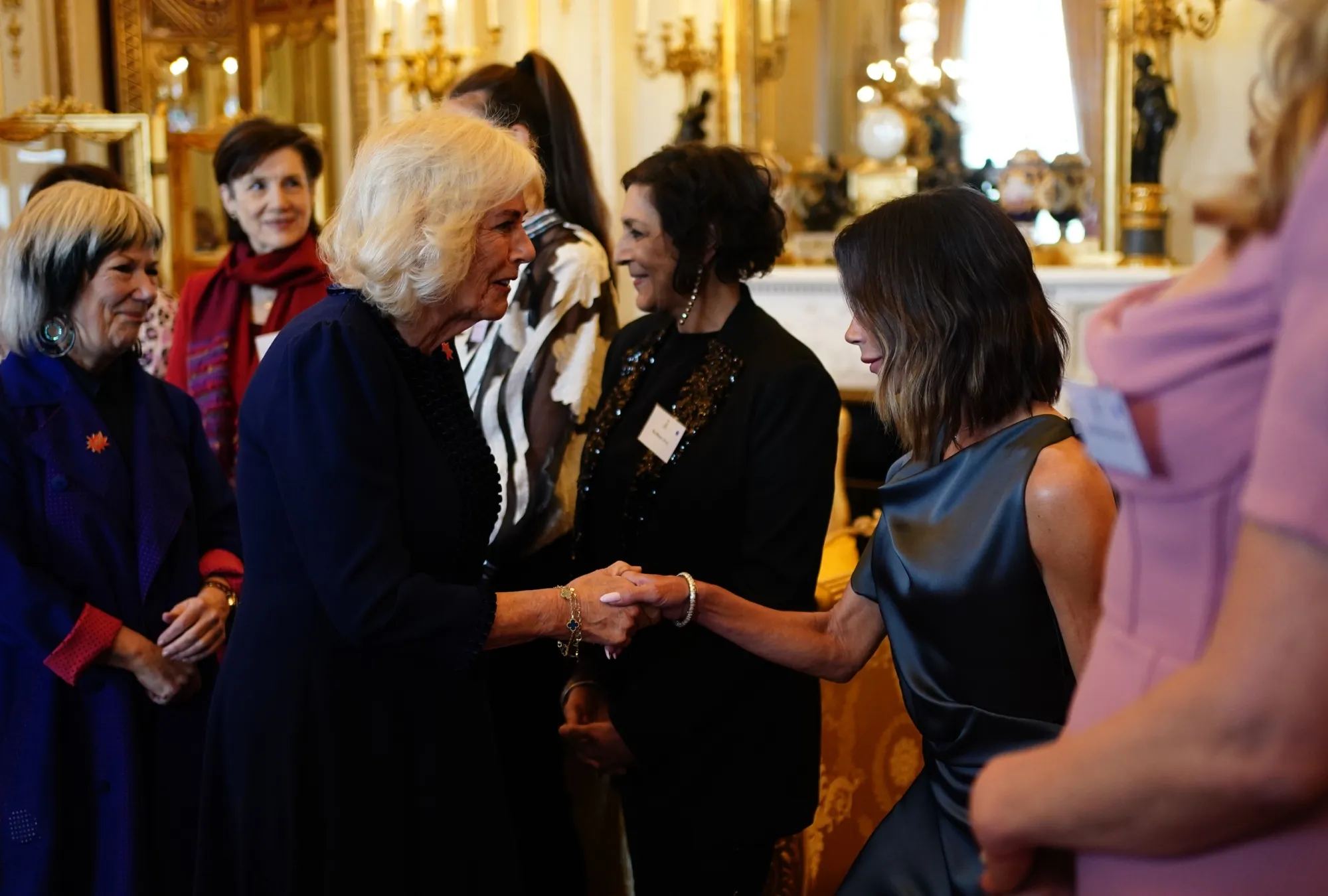 Victoria Beckham Stuns in Asymmetric Graphite Dress at Buckingham Palace